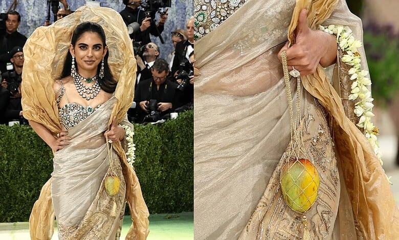 A woman in an elegant saree with floral accessories at the Met Gala, showcasing luxury fashion and style.