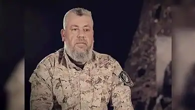 Hamas commander Izz al-Din al-Haddad wearing military uniform during a recorded appearance.