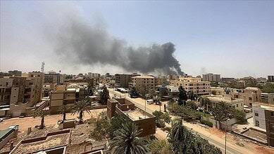 Explosion aftermath in Sudan city with smoke rising over buildings.
