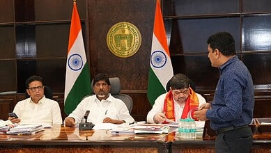 A government official discusses project details with officials at a formal meeting on Musi Rejuvenation.
