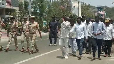Protesters walking on the street with police officers present, demonstrating public unrest and law enforc.