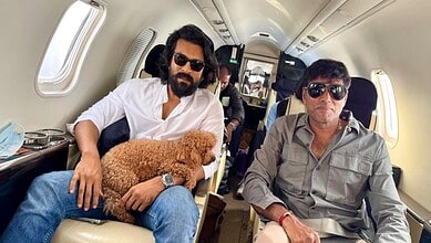 Ram Charan seated on a private jet with a dog, enjoying a travel moment.
