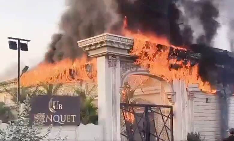 Fire engulfs Pista House Banquet Hall with thick black smoke and flames. Emergency services respond to co.