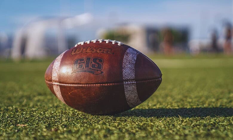 Image shows a rugby ball on the grass field at Gachibowli Stadium, Hyderabad, preparing for the Rugby Premier League event.