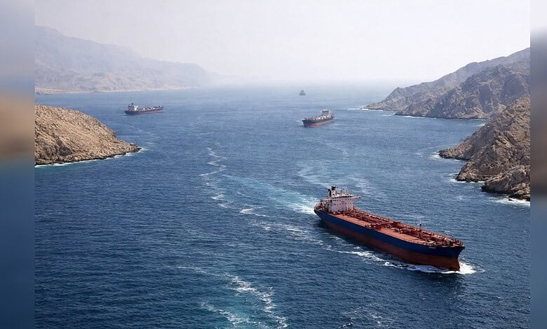 Oil tankers navigating a waterway between rugged coastal hills.