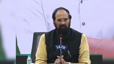 Indian Prime Minister speaking at a press conference with a microphone and backdrop.