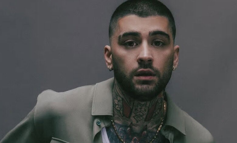 Zayn Malik with tattoos and serious expression, promoting tour update.